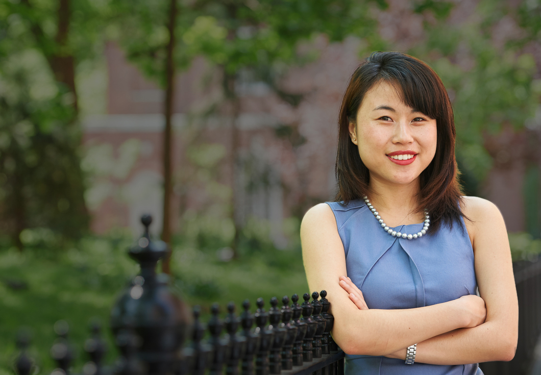 NYU Law graduate Alice Thai pictured in Washington Square Park with Vanderbilt Hall in the distance.